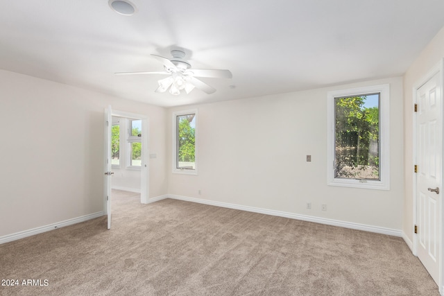 unfurnished room featuring ceiling fan and light carpet