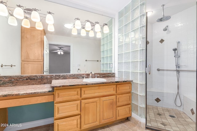 bathroom featuring a shower with door, vanity, ceiling fan, and tile patterned flooring