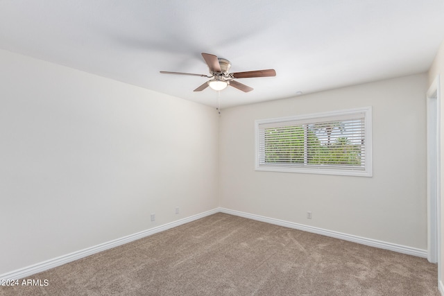 spare room with ceiling fan and light carpet