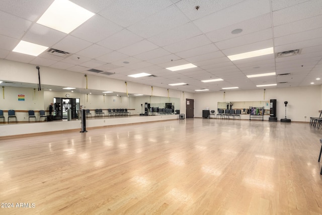 exercise area featuring a drop ceiling and light hardwood / wood-style floors