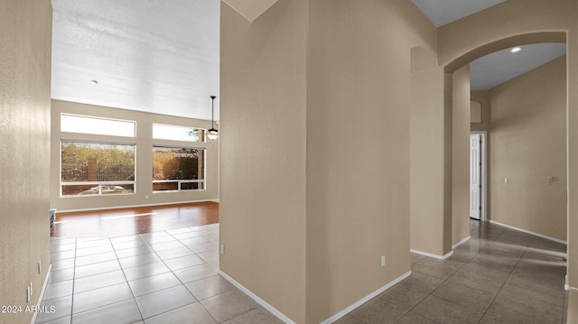 hall featuring tile patterned flooring and an inviting chandelier