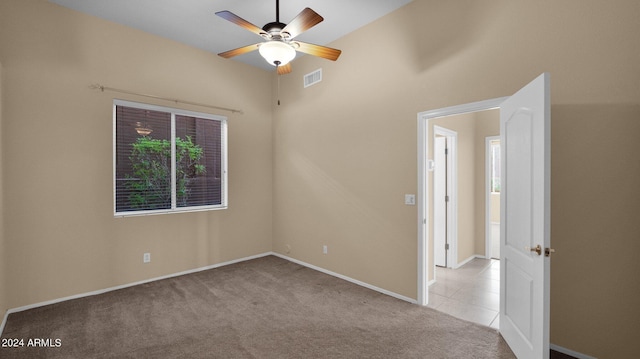 empty room featuring light carpet, a wealth of natural light, and ceiling fan