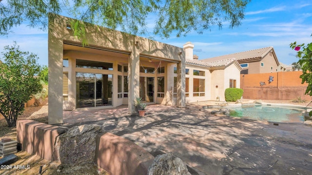 back of house with a fenced in pool and a patio area