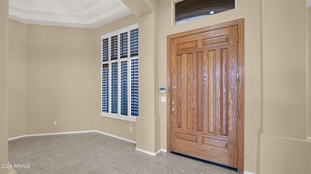 tiled entryway with a raised ceiling