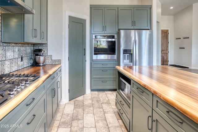 1014 Etta Ln, Show Low, AZ 85901 - kitchen featuring stainless steel appliances, under cabinet range hood, wooden counters, decorative backsplash, and recessed lighting