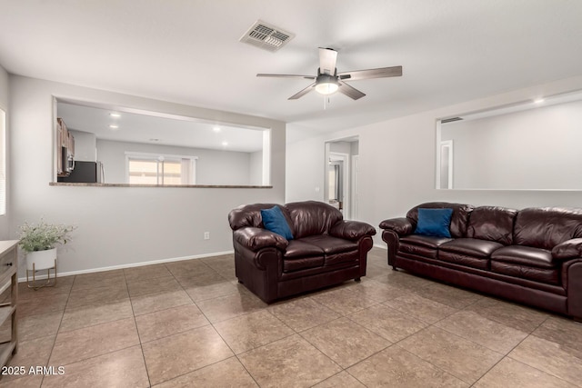 living room with light tile patterned floors, visible vents, a ceiling fan, and baseboards