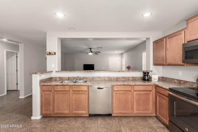 kitchen featuring recessed lighting, a peninsula, stainless steel appliances, a ceiling fan, and a sink