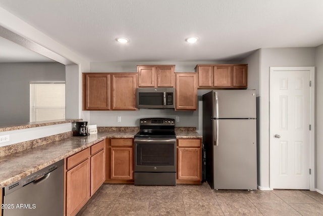 kitchen featuring brown cabinetry, recessed lighting, and stainless steel appliances