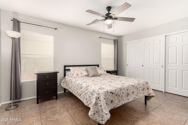 tiled bedroom featuring a closet, baseboards, and a ceiling fan