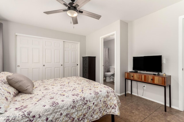 bedroom with tile patterned floors, ensuite bathroom, a closet, baseboards, and ceiling fan