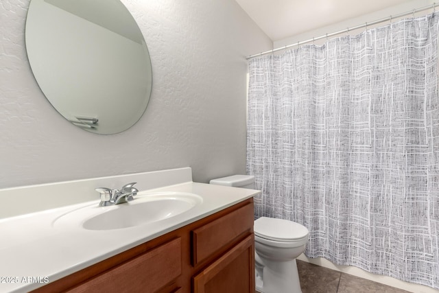 full bathroom featuring vanity, a shower with curtain, tile patterned floors, toilet, and a textured wall