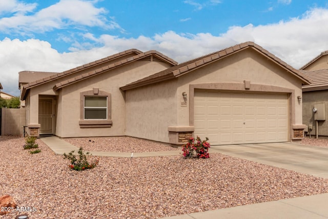 view of front facade with a tiled roof, a garage, driveway, and stucco siding