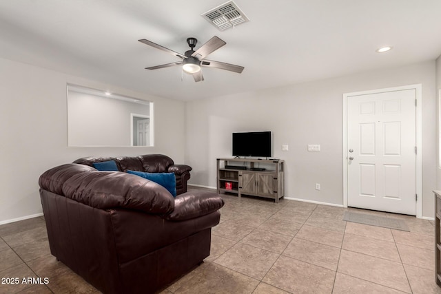 living room with light tile patterned floors, visible vents, ceiling fan, and baseboards