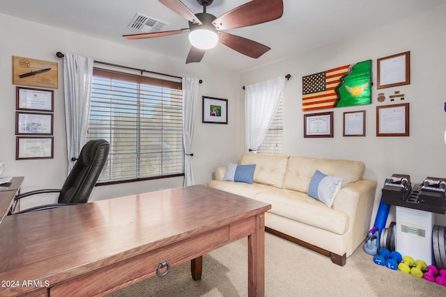 carpeted office space with ceiling fan