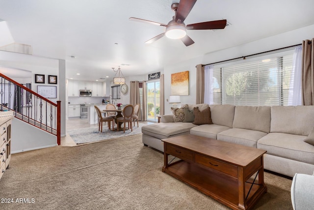 carpeted living room with ceiling fan