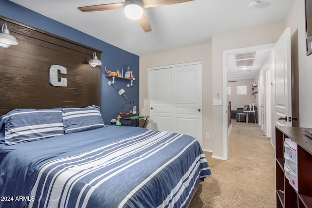 bedroom featuring ceiling fan, a closet, and light colored carpet