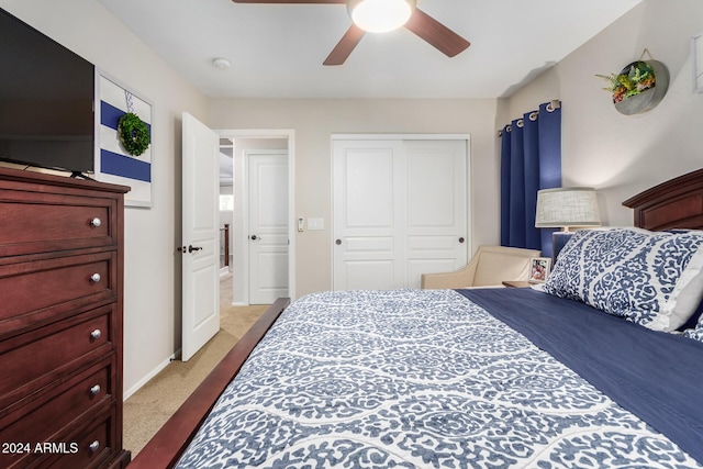 carpeted bedroom featuring ceiling fan and a closet