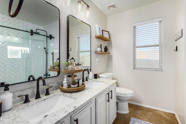 bathroom featuring tile patterned floors, vanity, tiled shower, and toilet