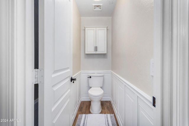 bathroom with hardwood / wood-style flooring and toilet