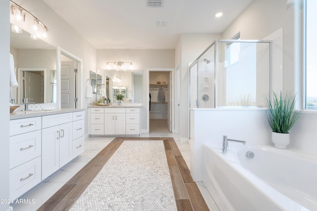 bathroom with vanity and separate shower and tub