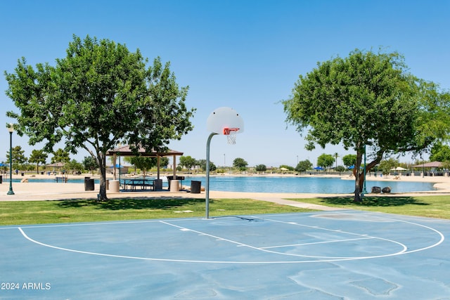 view of basketball court featuring a gazebo, a water view, and a yard