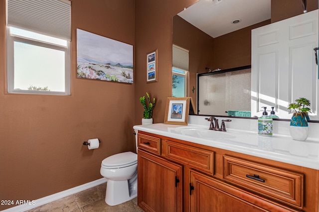 bathroom featuring tile patterned floors, vanity, toilet, and a shower with shower door