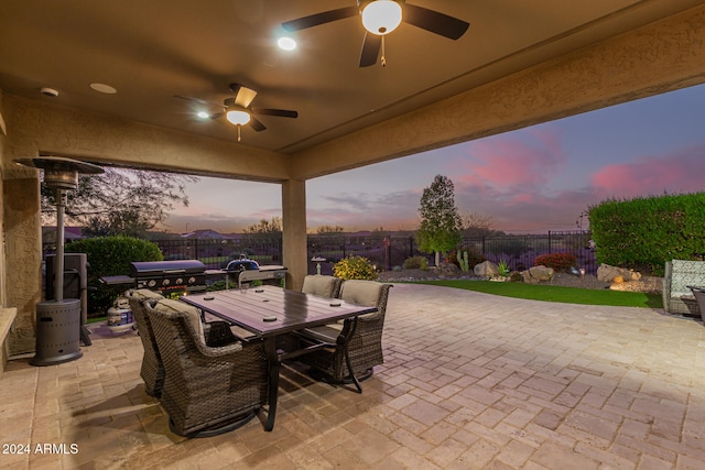 patio terrace at dusk with area for grilling and ceiling fan