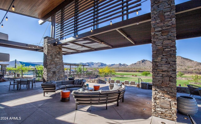 view of patio / terrace featuring a mountain view, an outdoor living space, and a pergola