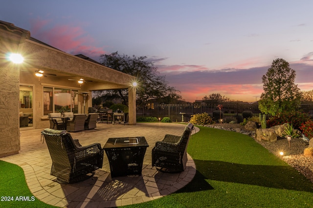 patio terrace at dusk with outdoor lounge area and a yard