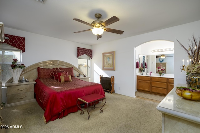 carpeted bedroom featuring ensuite bathroom and ceiling fan