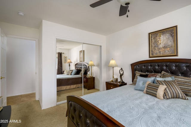 bedroom with ceiling fan, light carpet, and a closet