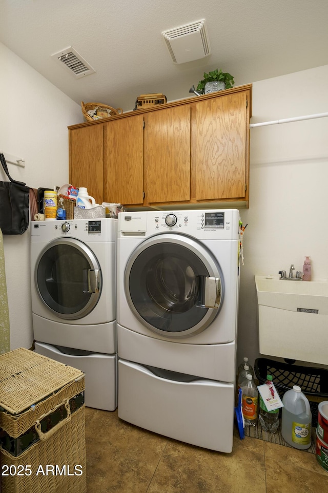 washroom with washing machine and dryer, sink, and cabinets