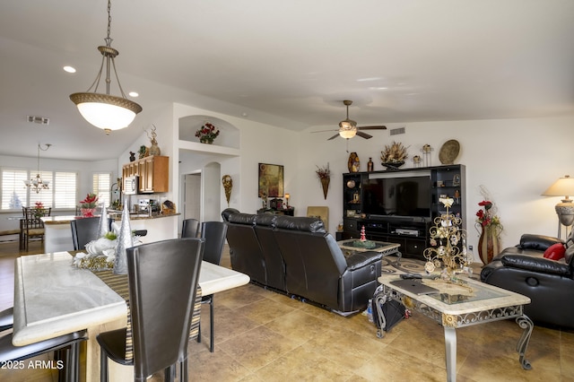 living room featuring ceiling fan with notable chandelier and vaulted ceiling