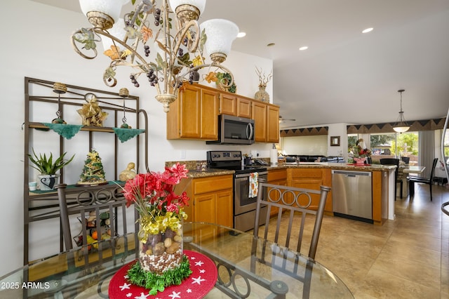 kitchen with ceiling fan, sink, hanging light fixtures, kitchen peninsula, and appliances with stainless steel finishes