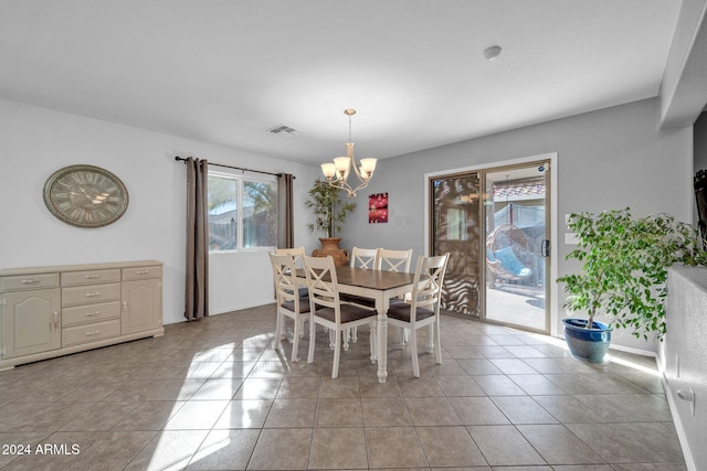 tiled dining area featuring a chandelier