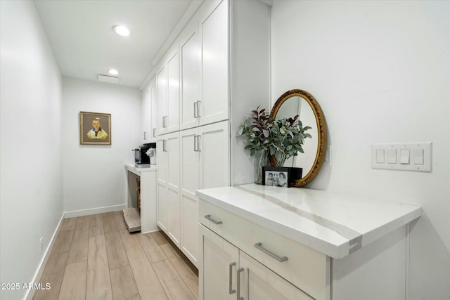 bar featuring light wood-style flooring, baseboards, and recessed lighting