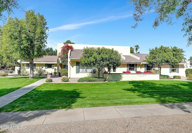 ranch-style house featuring stucco siding and a front yard