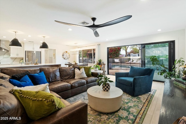 living room with light wood-type flooring, ceiling fan, visible vents, and recessed lighting