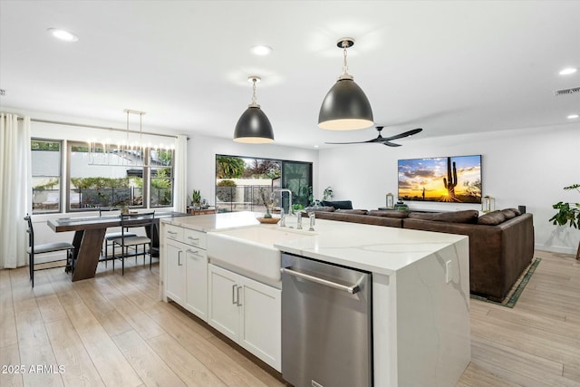 kitchen featuring a sink, white cabinetry, light wood-type flooring, a wealth of natural light, and dishwasher