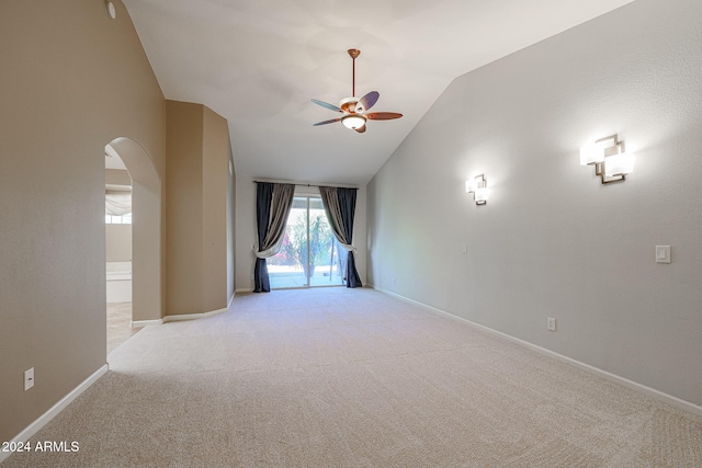 carpeted spare room featuring ceiling fan and vaulted ceiling