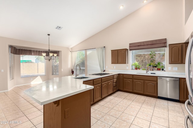 kitchen featuring kitchen peninsula, plenty of natural light, a notable chandelier, and appliances with stainless steel finishes