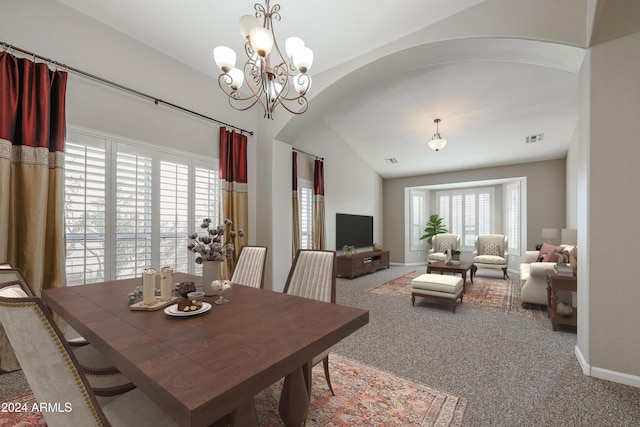 dining room featuring carpet flooring, vaulted ceiling, and an inviting chandelier