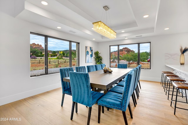 dining room featuring baseboards, visible vents, a tray ceiling, recessed lighting, and light wood-type flooring