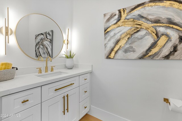 bathroom with vanity, baseboards, and wood finished floors