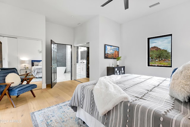 bedroom featuring light wood-style flooring, connected bathroom, visible vents, and ceiling fan