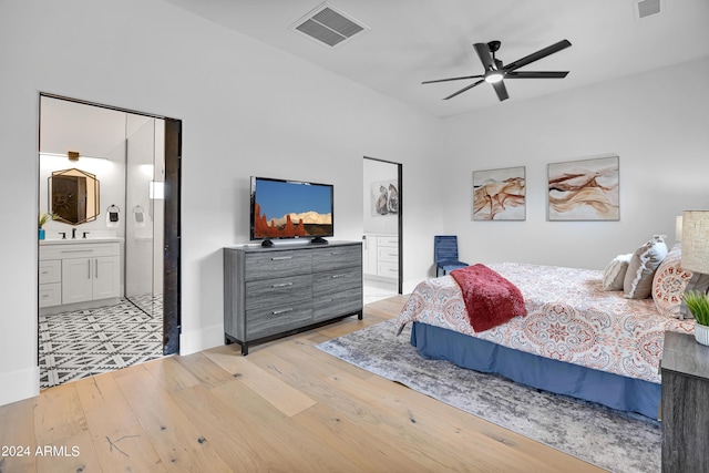 bedroom featuring ensuite bath, light wood-style floors, visible vents, and ceiling fan