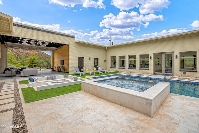 outdoor pool with an in ground hot tub, french doors, and a patio