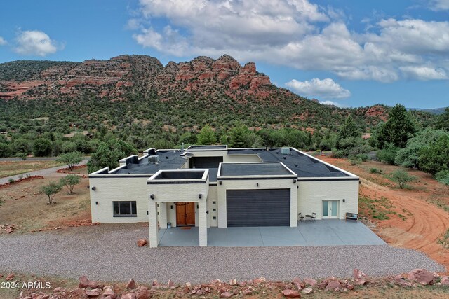 view of front of house featuring a mountain view, concrete driveway, and an attached garage