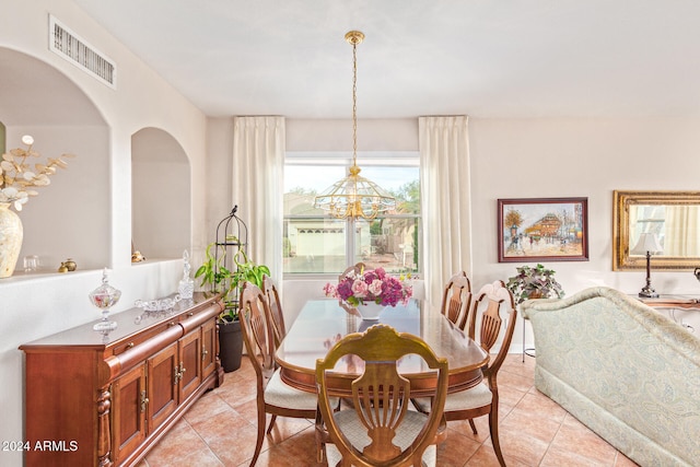 dining area featuring light tile patterned flooring and an inviting chandelier