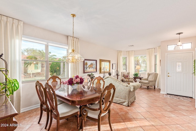 tiled dining area featuring a notable chandelier